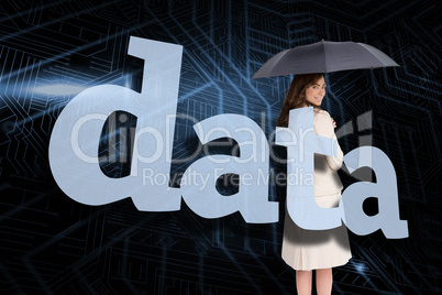 Businesswoman holding umbrella behind the word data