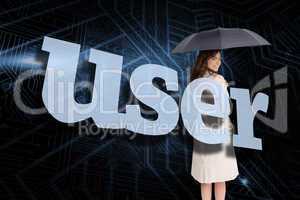 Businesswoman holding umbrella behind the word user
