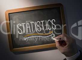 Hand writing Statistics on chalkboard