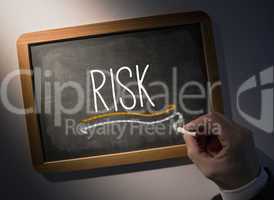 Hand writing Risk on chalkboard