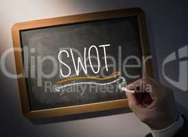 Hand writing Swot on chalkboard