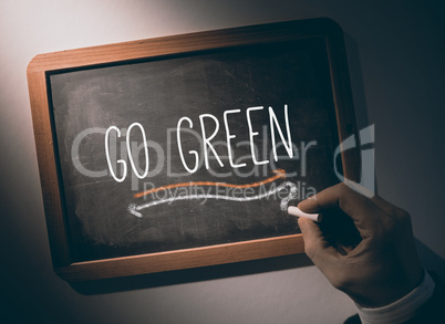 Hand writing go green on chalkboard