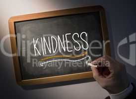 Hand writing Kindness on chalkboard
