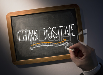Hand writing Think positive on chalkboard