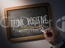 Hand writing Think positive on chalkboard