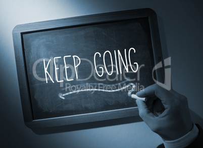 Hand writing Keep going on chalkboard