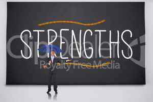 Businessman holding umbrella against the word strengths