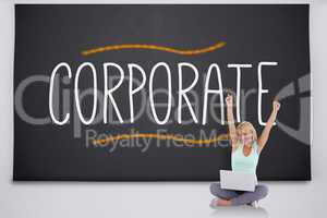 Cheering blonde with laptop against the word corporate