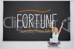 Cheering blonde with laptop against the word fortune