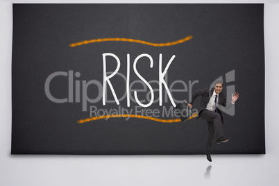 Happy businessman jumping against the word risk