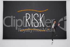Happy businessman jumping against the word risk