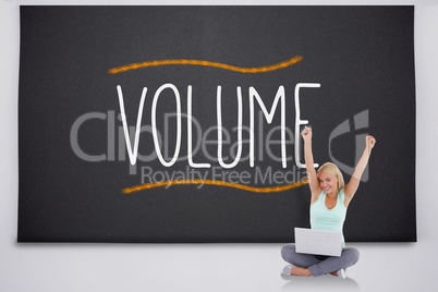 Cheering blonde using laptop against the word volume