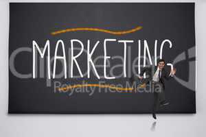 Happy businessman jumping against the word marketing