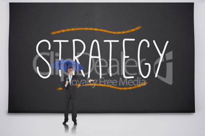 Businessman holding umbrella against the word strategy