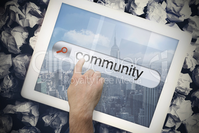 Hand touching community on search bar on tablet screen