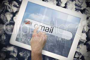 Hand touching email on search bar on tablet screen