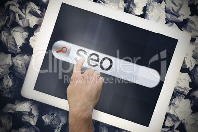 Hand touching seo on search bar on tablet screen