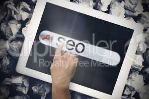 Hand touching seo on search bar on tablet screen