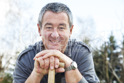 man in the garden draws on spade handle