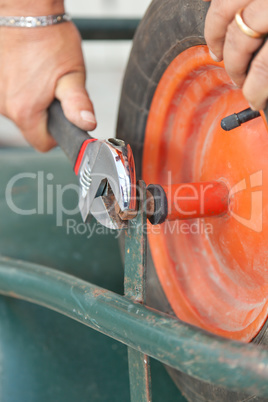 Replacing the tire of a wheelbarrow.