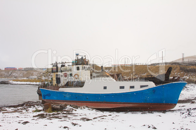 the boat on the bank of the winter ocean