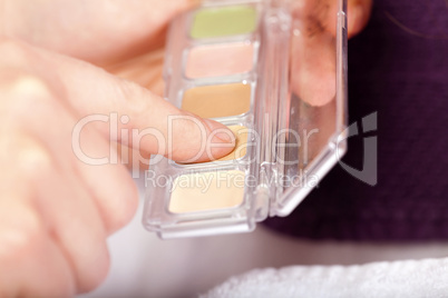kosmetikerin wählt farbe für einen lidschatten aus