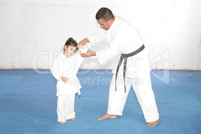 black belt karate teaching a little girl