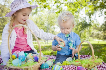Cute Young Brother and Sister Enjoying Their Easter Eggs Outside
