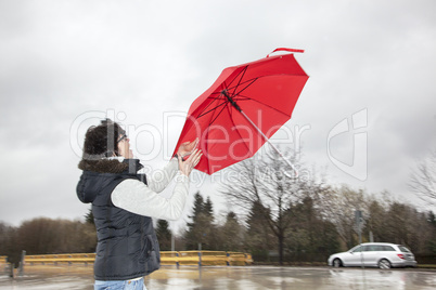woman is running her umbrella flying away