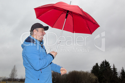 man running with umbrella in rainy stormy weather
