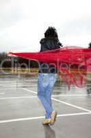 woman running in rainy weather with red cloth