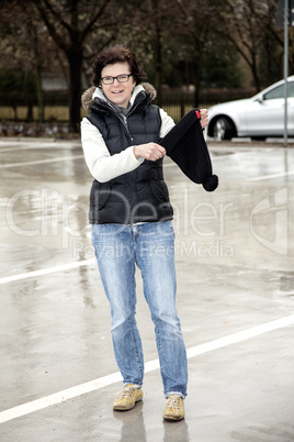 woman with wool hat walks across the parking