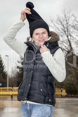 woman with wool hat walks across the parking