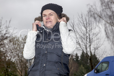 woman with wool hat walks across the parking