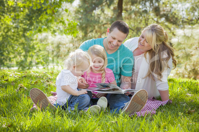 Young Family Enjoys Reading a Book in the Park