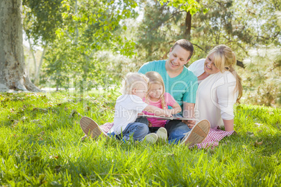 Young Family Enjoys Reading a Book in the Park