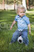 Young Cute Boy Playing with Soccer Ball in Park