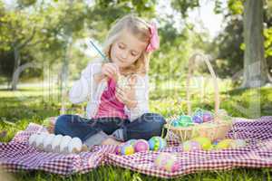 Cute Young Girl Coloring Her Easter Eggs with Paint Brush