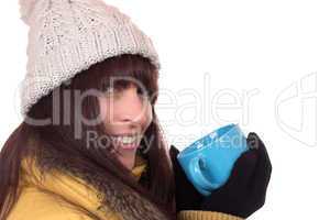 Lachende Frau trinkt eine heiße Tasse Tee im Winter