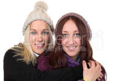 Zwei junge Frauen im Wintermantel umarmen sich