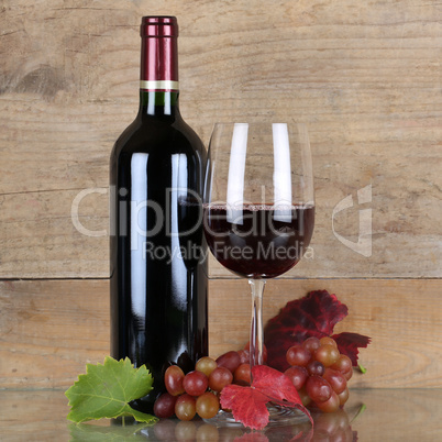 Rotwein in Weinflasche vor einem Hintergrund aus Holz