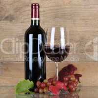Rotwein in Weinflasche vor einem Hintergrund aus Holz