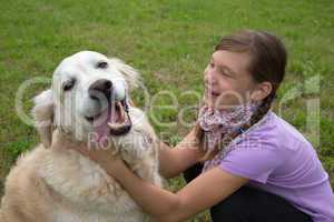 Kind und Hund spielen auf Wiese