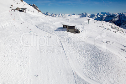 Skipiste mit Skifahrern und Snowboardern in den Bergen