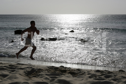 Junger Mann beim Laufen Joggen Training am Strand