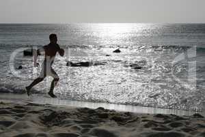 Junger Mann beim Laufen Joggen Training am Strand