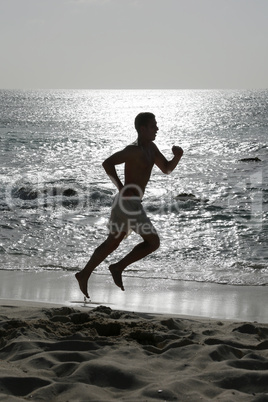 Junger Sportler beim Laufen Joggen Training am Strand