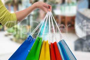 eine junge frau hält einkaufstaschen in der hand in einer shopp