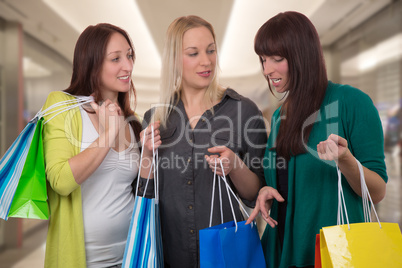 gruppe junger frauen schaut auf die einkäufe in shopping mall