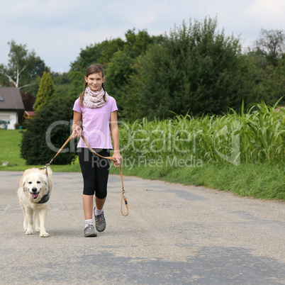 mädchen geht mit golden retriever hund gassi